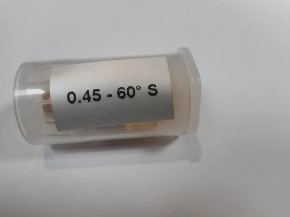 Transparente Kunststoffhülse mit einer Düse von Remeha, beschriftet mit "0.45 - 60° S". Innerhalb sind verschiedene Teile zu erkennen.